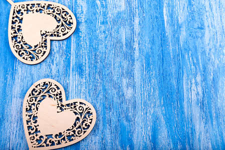 carved wooden hearts on Valentine's Day, with space for text on a blue wooden backgroundの写真素材