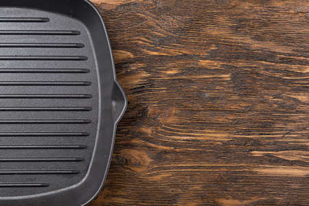 empty grill pan on a wooden background, space for writing recipeの写真素材