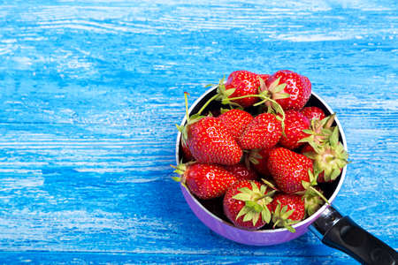Ripe red strawberries on wooden table in natural backgroundの写真素材