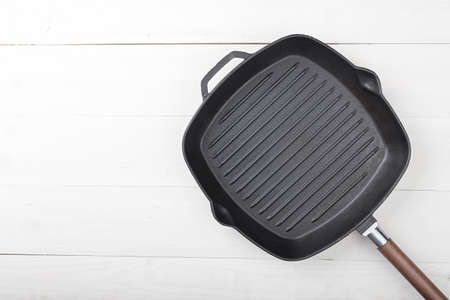 empty grill pan on a wooden background, space for writing recipeの写真素材