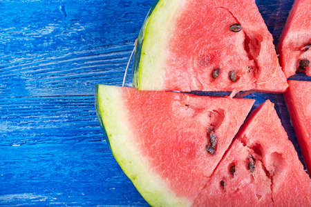 sliced ripe watermelon on a wooden background, top view
