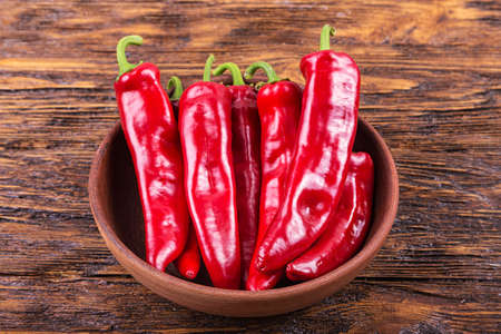 red pepper in a clay plate on dark wooden surfaceの写真素材