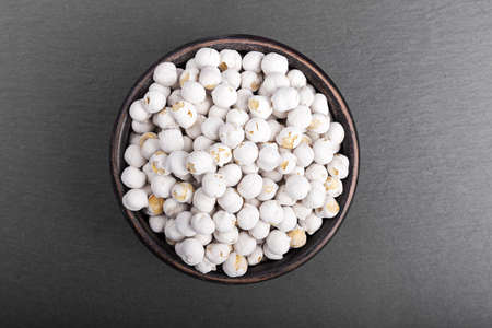 chickpeas in a bowl on black slate background; top view