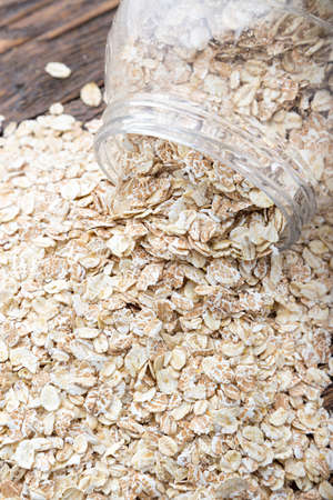 raw oatmeal is scattered on the desk of the bank in which the oat flakes are stored