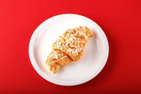 Traditional nourishing breakfast croissant in a dish on a red backgroundの写真素材