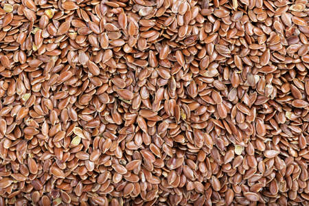 a lot of flax seeds are scattered as a background, close upの写真素材