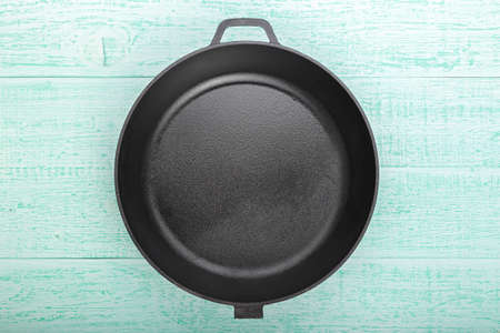 empty cast-iron frying pan on a wooden backgroundの写真素材