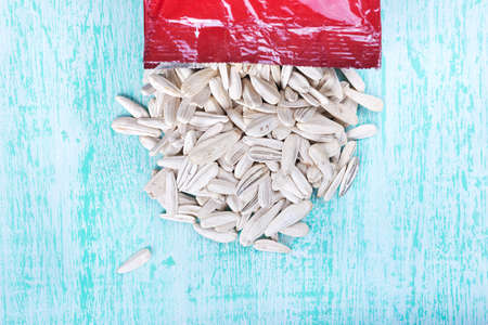 white sunflower seeds in open packaging, on wooden backgroundの写真素材