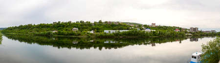 View from the banks of the Dniester River in Mogilev-Podolsky, Ukraine, on Moldovan houses on the opposite bank of the river, horizontal photoの写真素材