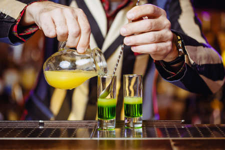 A real cocktail shot of a green Mexican with banana liqueur, lemon juice and tequila. Horizontal...