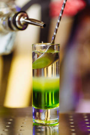 Cocktail shot green mexican with banana liqueur, lemon juice and tequila. Vertical photoの写真素材