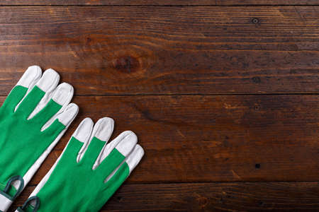 New and clean construction gloves on a wooden background, space for text, horizontal photoの写真素材