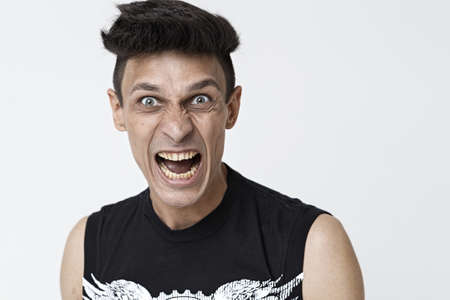 Emotional man screaming on white background. Expressive young man. Horizontal photo