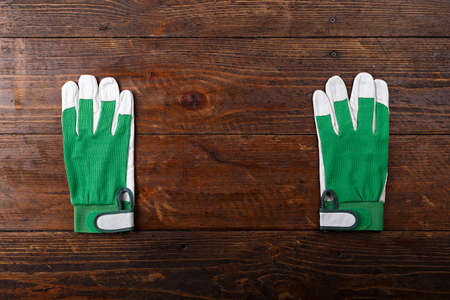 New and clean construction gloves on a wooden background, space for text, horizontal photoの写真素材