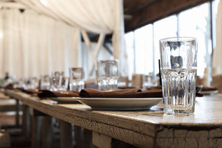 The beginning of the banquet. Empty glasses for juice or water on a served table in a restaurant, horizontal photoの写真素材