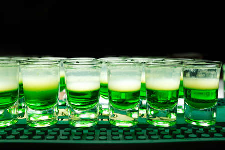 night life. A lot of green Mexican cocktails stand on the bar, horizontal photo.