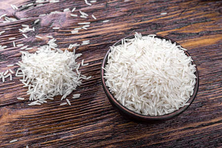 traditional food, uncooked rice in a bowl on a wooden backgroundの写真素材
