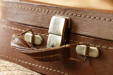 Old vintage suitcase in the room. The suitcase handle. Foreground, horizontal photoの写真素材