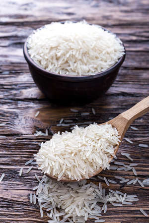 traditional food, uncooked rice in a bowl on a wooden backgroundの写真素材