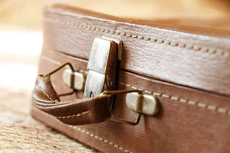 Old vintage suitcase in the room. The suitcase handle. Foreground, horizontal photoの写真素材