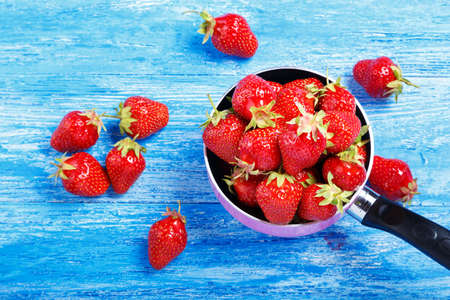 Ripe red strawberries on wooden table in natural backgroundの写真素材