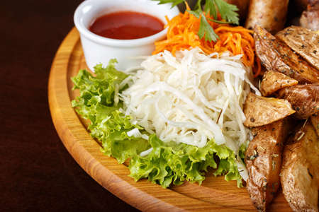 Appetizing background fried potatoes with spices and with vegetables - carrots in Korean and cabbage. Next is a tomato sauceの写真素材