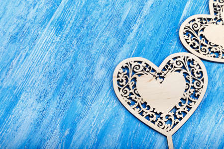 carved wooden hearts on Valentine's Day, with space for text on a blue wooden backgroundの写真素材