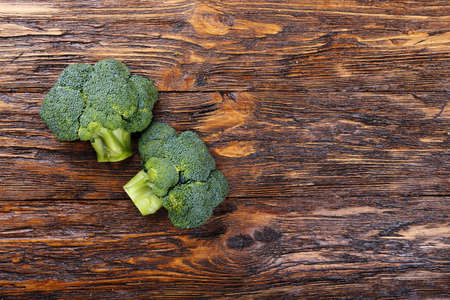 Inflorescence of raw broccoli on a wooden table, With space for text, horizontal shot