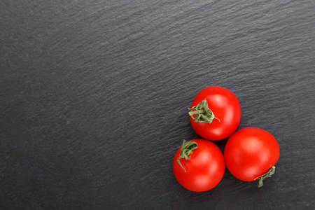 Ripe tomatoes place for text, tomatoes on a black backgroundの写真素材