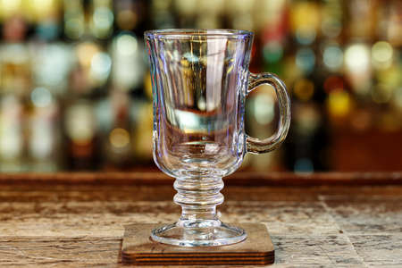 A clean punch glass on the bar, a glass glass with a handle on the blurred background of the barの写真素材