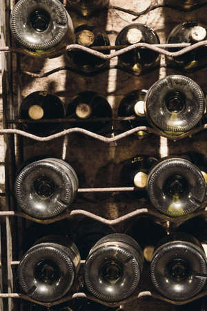 Many bottles of wine in the cellar are stacked in dense rows on the shelves, winemakingの写真素材