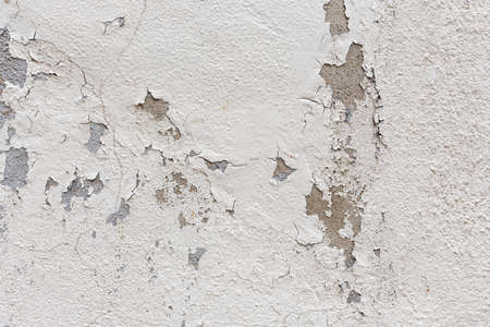 old wall with peeling white plaster texture