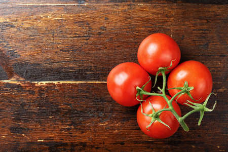 Raw fresh cherry tomatoes on a wooden background, top viewの写真素材