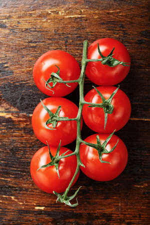 Raw fresh cherry tomatoes on a wooden background, top viewの写真素材