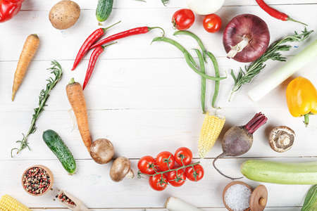 Summer vegetables on a white wooden background. carrots, tomatoes, onions, corn, peppers. place for...