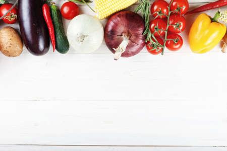 Summer vegetables on a white wooden background. carrots, tomatoes, onions, corn, peppers. place for textの写真素材