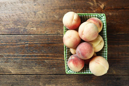harvest ripe peaches on a table, on a dark brown wooden backgroundの写真素材