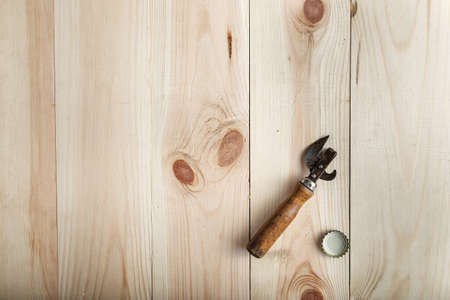 Vintage Opener near the lid of beer, on a wooden background, space for textの写真素材