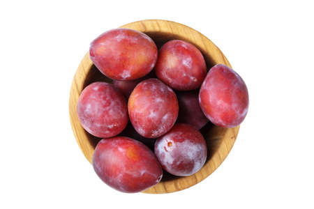 ripe plums in a wooden plate on a white background, isolated? top viewの写真素材