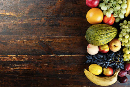 fruit background with exotic fruits on a brown wooden background, fruit detox, space for textの写真素材