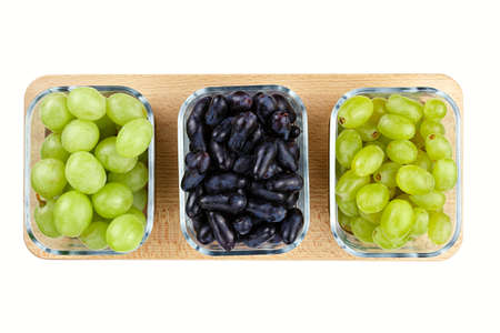 three different grape varieties in glass plates on a wooden stand, isolatedの写真素材