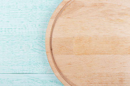 round pizza board on a wooden background, space for textの写真素材