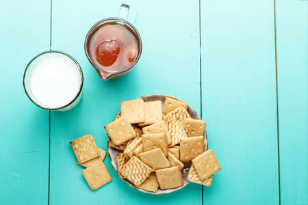 delicious breakfast crackers with jam and milk on a wooden surface
