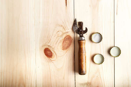 Vintage Opener near the lid of beer, on a wooden background, space for textの写真素材