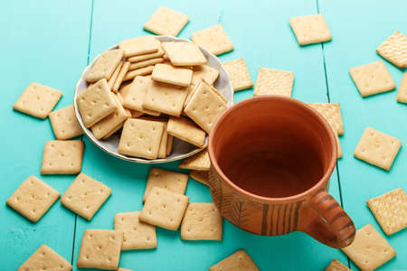 Empty clay cup and crackers scattered on the tableの写真素材