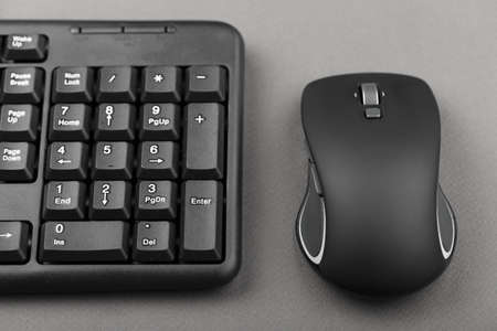 black computer mouse near the keyboard, office equipment on the tableの写真素材