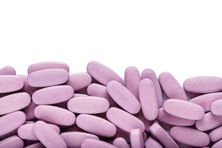 large pink pills scattered on white background, isolated