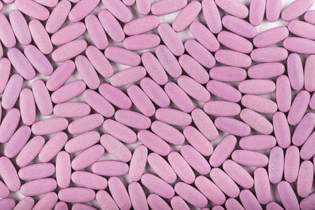 many large pink tablets are scattered as a background, space for textの写真素材