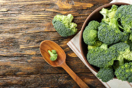 broccoli in a clay plate on a wooden table. with space for textの写真素材