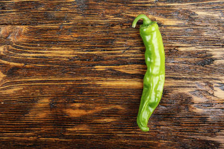 green pepper on wooden surface. Horizontal photo with free space area for text or design.の写真素材